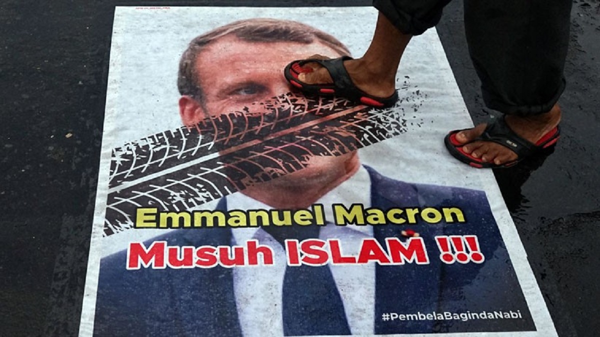 Pengguna jalan menginjak poster berwajah Presiden Prancis Emmanuel Macron
