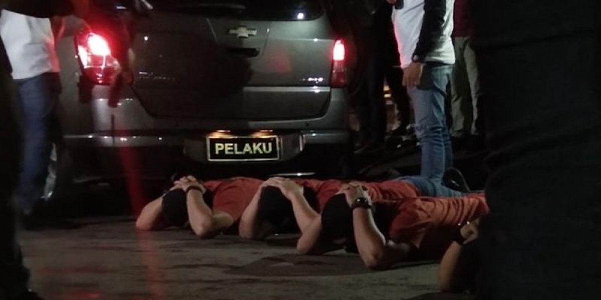Adegan saat empat orang laskar FPI yang diturunkan dari mobil Chevrolet Spin sebelum dibawa ke mobil polisi